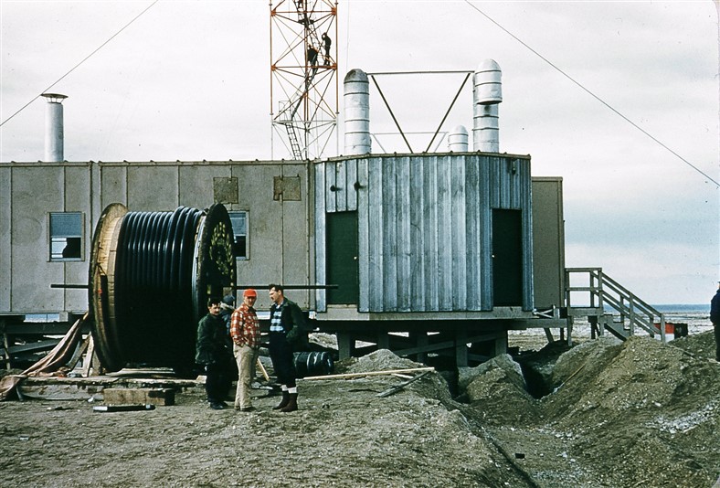 Getting ready to install (bury) the Styroflex cable between the transmitter module and the antenna. Note the two workers on the tower in the background. Aug 1956.