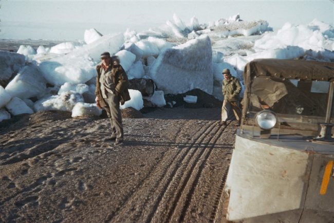 Walt Knopps in front of ice piled up over the road. June 1953.