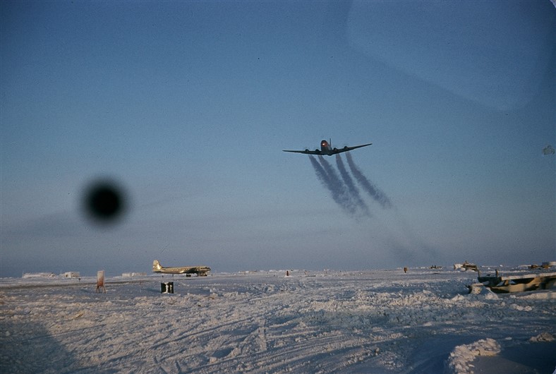 A C-124 leaving vapour trails as it takes off from POW-Main. Feb 1955.