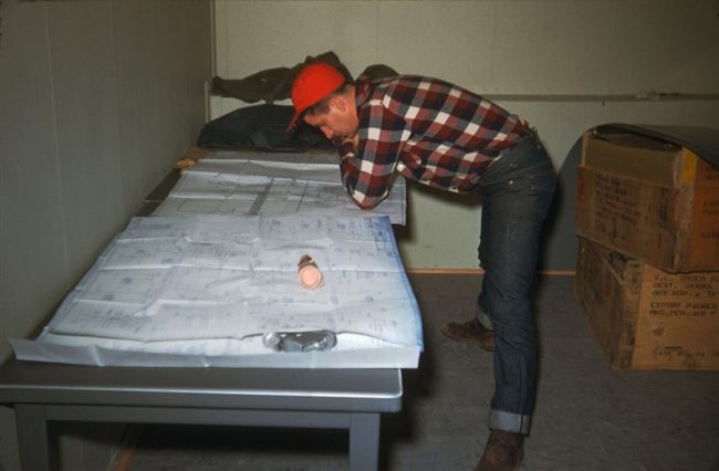 Bob Evans pouring over site blueprints. Oct 1953.